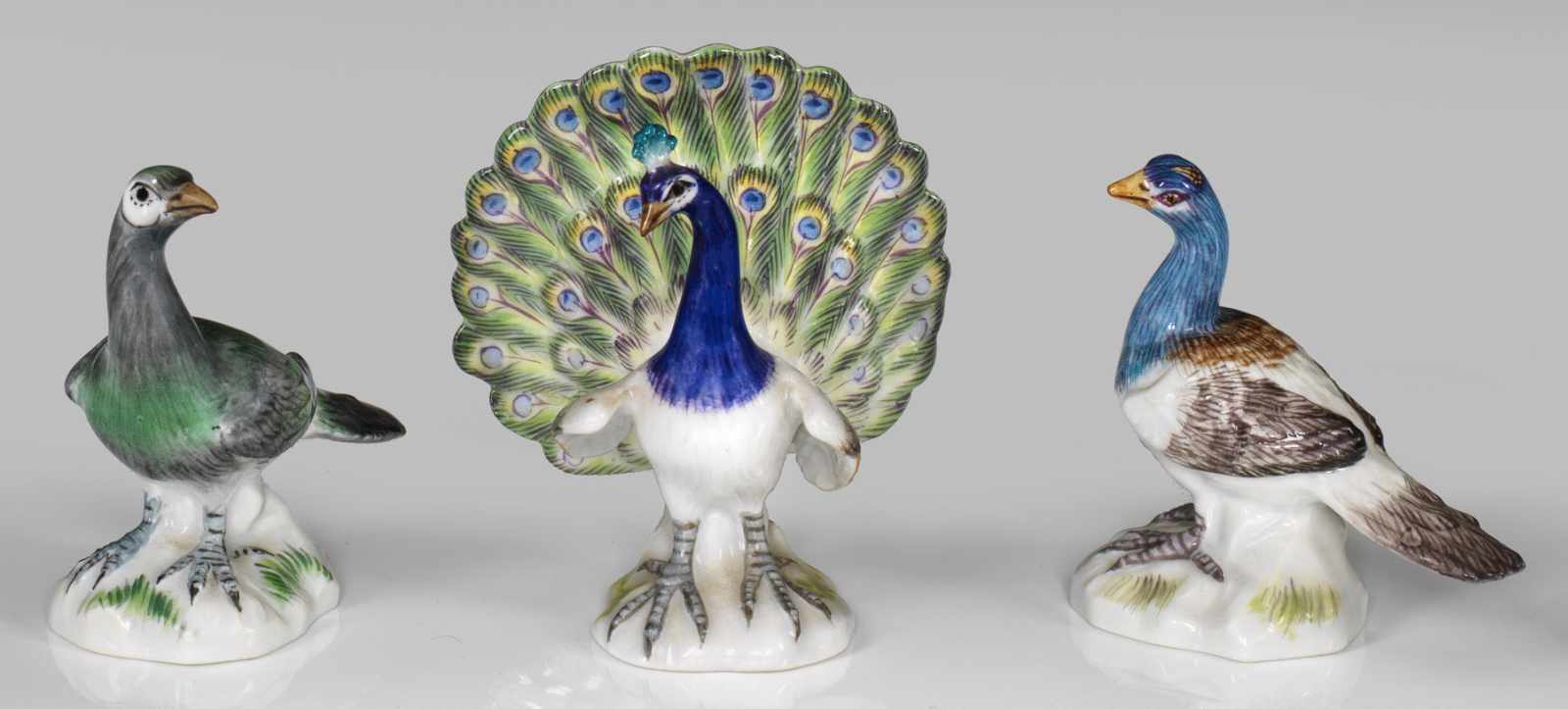 Drei Miniatur-TierfigurenRadschlagender Pfau und zwei Tauben in äußerst naturalistischer