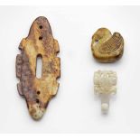 Drei Jadeschnitzereien im archaischen StilCremeweiße bis rostrote und karamellfarbene Jade sowie