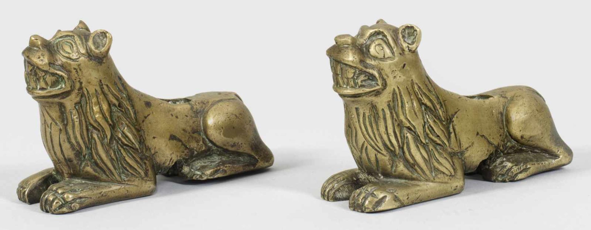 Paar ruhende LöwenGegenstücke. Bronze. Vollplastisch gestaltete liegende Löwen mit erhobenem Kopf.