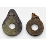 Zwei Bi-Scheiben im archaischen StilSeladongrüne bis rostbraune Nephrit-Jade. Geschnitzt. Beidseitig