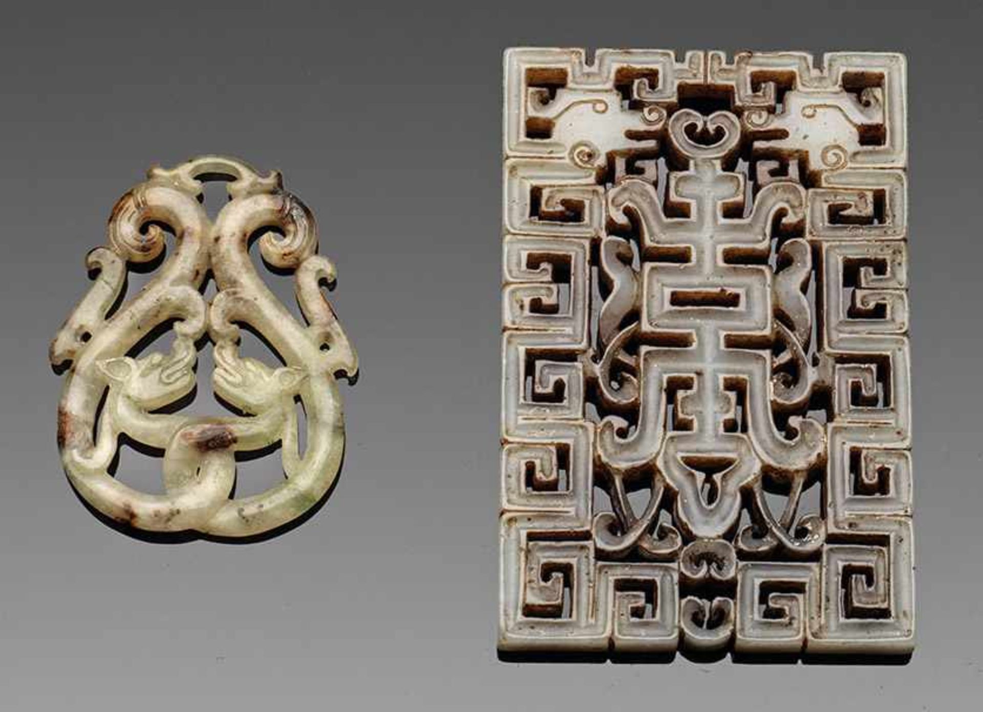 Anhänger und Plakette im archaischen StilGrauweiße und helle, seladongrüne Jade mit rost- bis