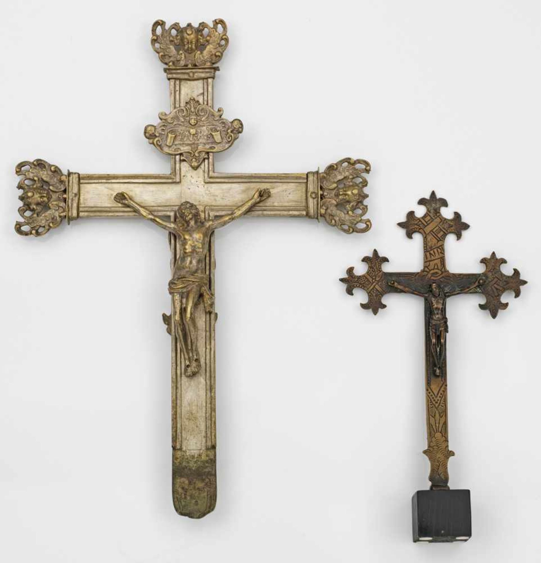 Zwei KruzifixeBronze, vergoldet und versilbert bzw. Messing, braun patiniert. Vollplastischer Corpus