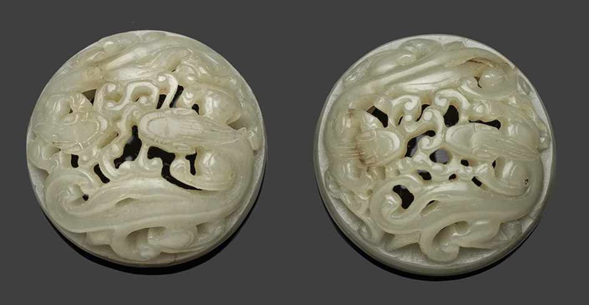 Paar JadeschnitzereienHelle, seladongrüne Nephrit-Jade. Runde, gewölbte Form. Feine, geschnitzte