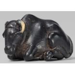 A fine small ebony wood netsuke of a recumbent ox. 19th centuryBoth forelegs tucked under the