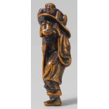 A boxwood netsuke of Shôki and an oni. Late 18th centuryThe demon queller standing on one foot,