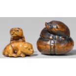 Two boxwood netsuke. 19th centurya) Two playing puppies, b) a recumbent piebald puppy on a kemari