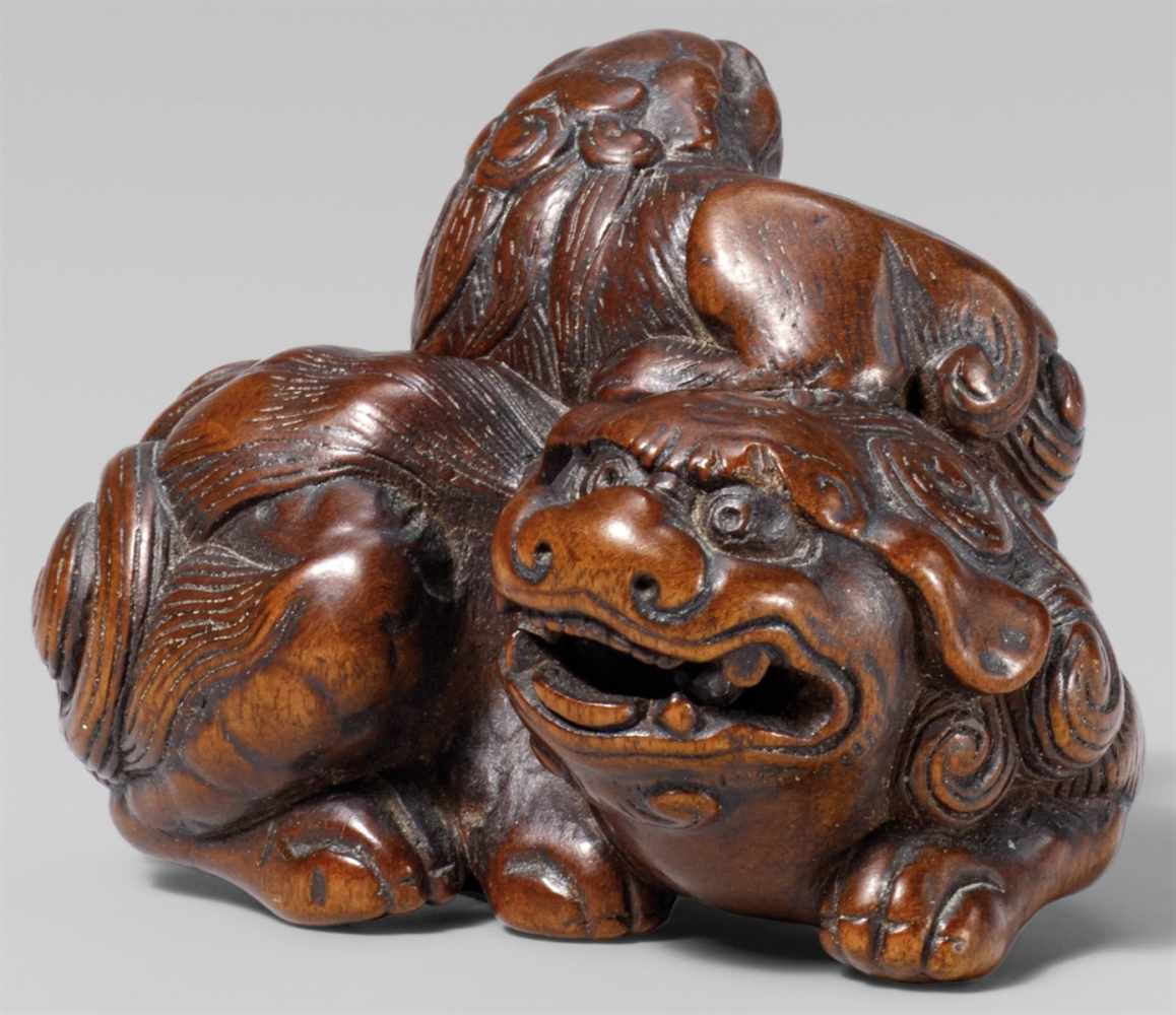 A wood netsuke of a shishi with young. Late 18th/early 19th centuryThe parent recumbent, snarling