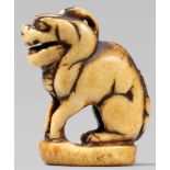 A stag antler seal-type netsuke of a mythical beast. Early 19th centurySeated on an oval base. The