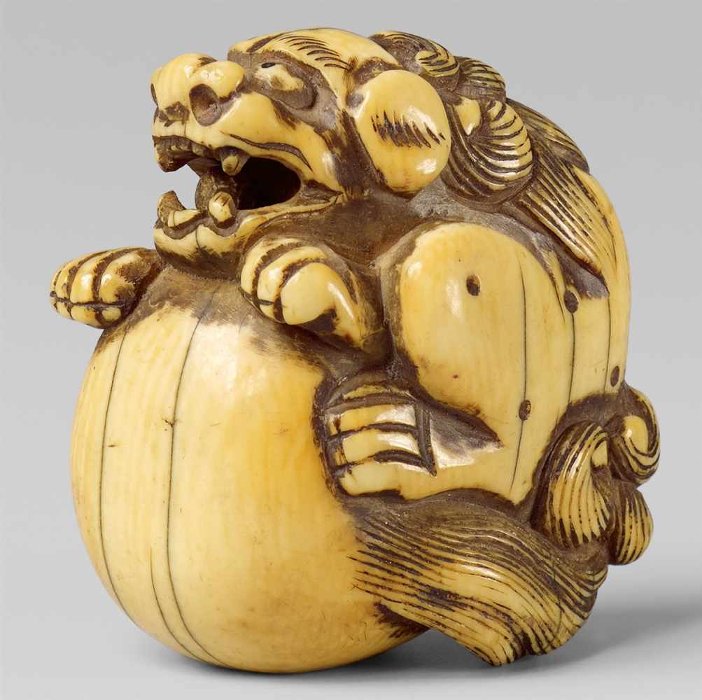 An ivory netsuke of a shishi with a ball. Late 18th/early 19th centuryOf triangular shape, trying to