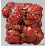 A lacquer netsuke of two shishi. Late 19th centuryBoth animals biting the other's rear paw, thus