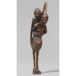 A boxwood netsuke of ashinaga and tenaga. 19th centuryThe long-armed tenaga with a cowry in his