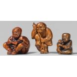 Three boxwood netsuke. 19th centurya) A peasant carrying two captured oni in his big bag, b) a