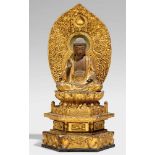 Amida Nyorai. Holz, über Schwarzlack vergoldet. 17./18. Jh.Im Meditationssitz auf einem doppelten