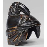 A black-lacquered wood netsuke of a kabuki actor's headdress. 19th centuryThe iconic headdress of