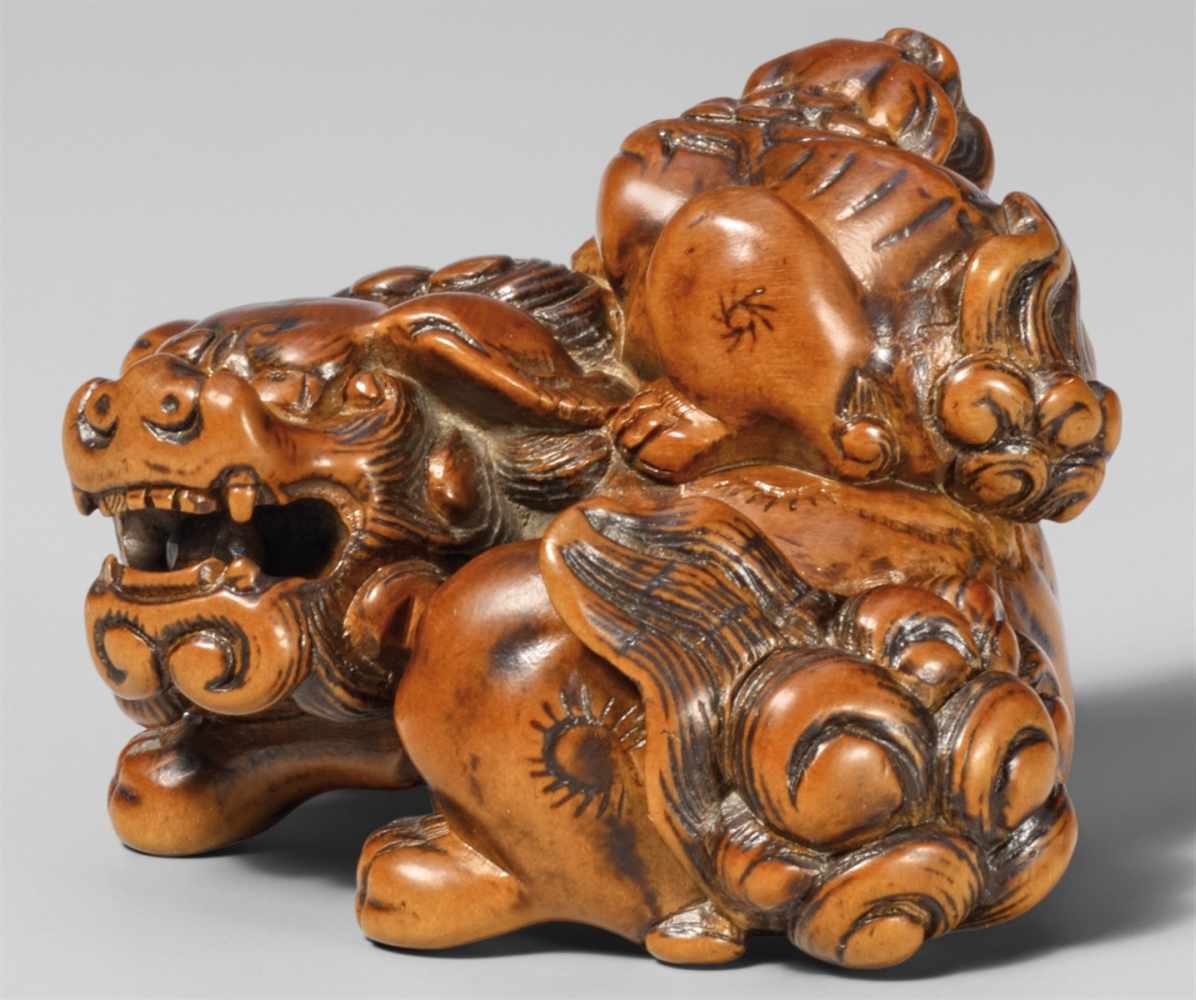 A powerful boxwood netsuke of a shishi and a cub. Late 18th centuryThe cub sitting on the back of