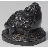 A black wood netsuke of a toad. 19th centurySeated on a tree trunk's circular cross-section, head