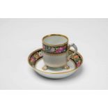 A Meissen porcelain cup with a floral wreathWith original saucer. Blue crossed swords mark with star