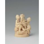 A carved ivory group of two putti with a ramA small group comprising a sitting female and a