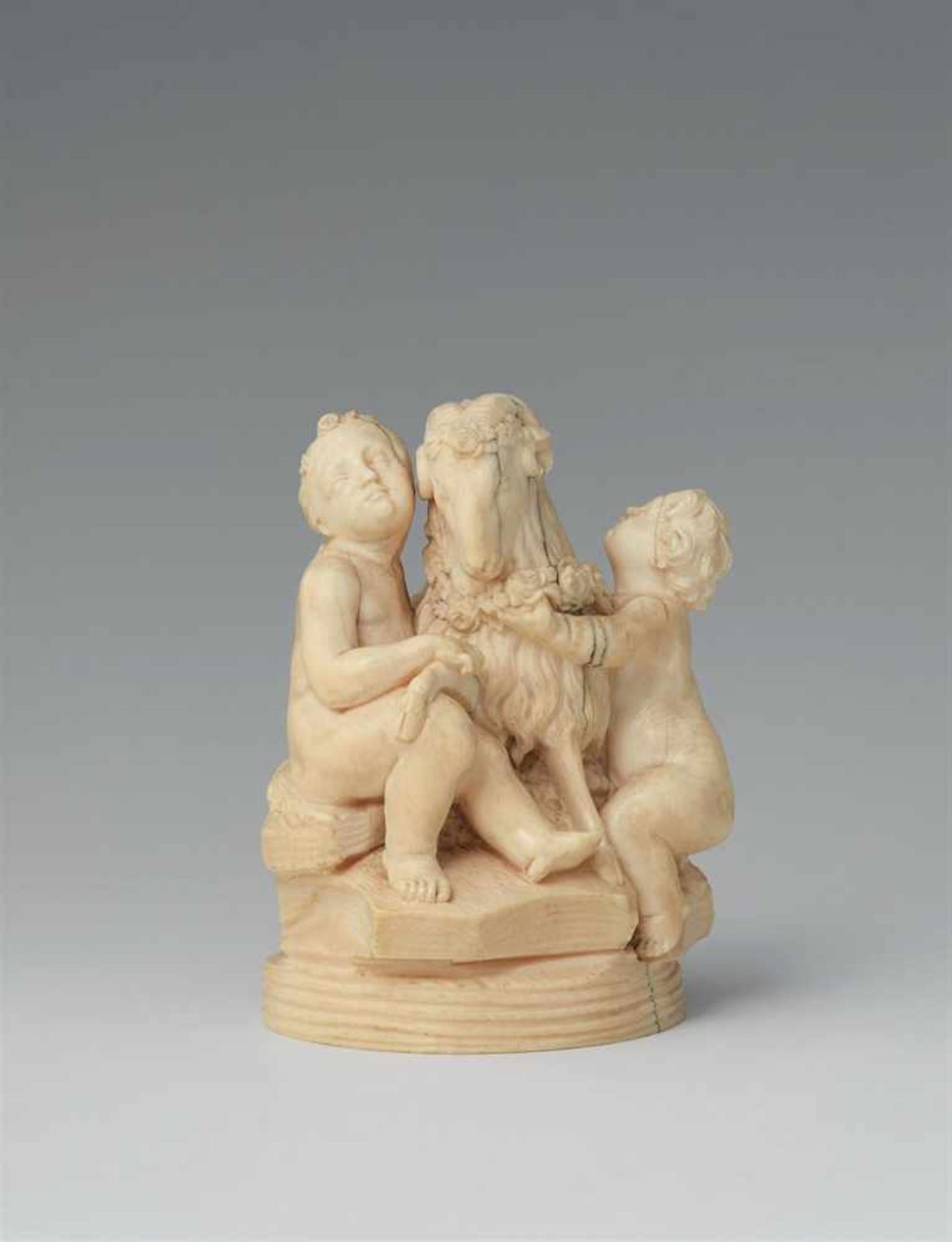 A carved ivory group of two putti with a ramA small group comprising a sitting female and a