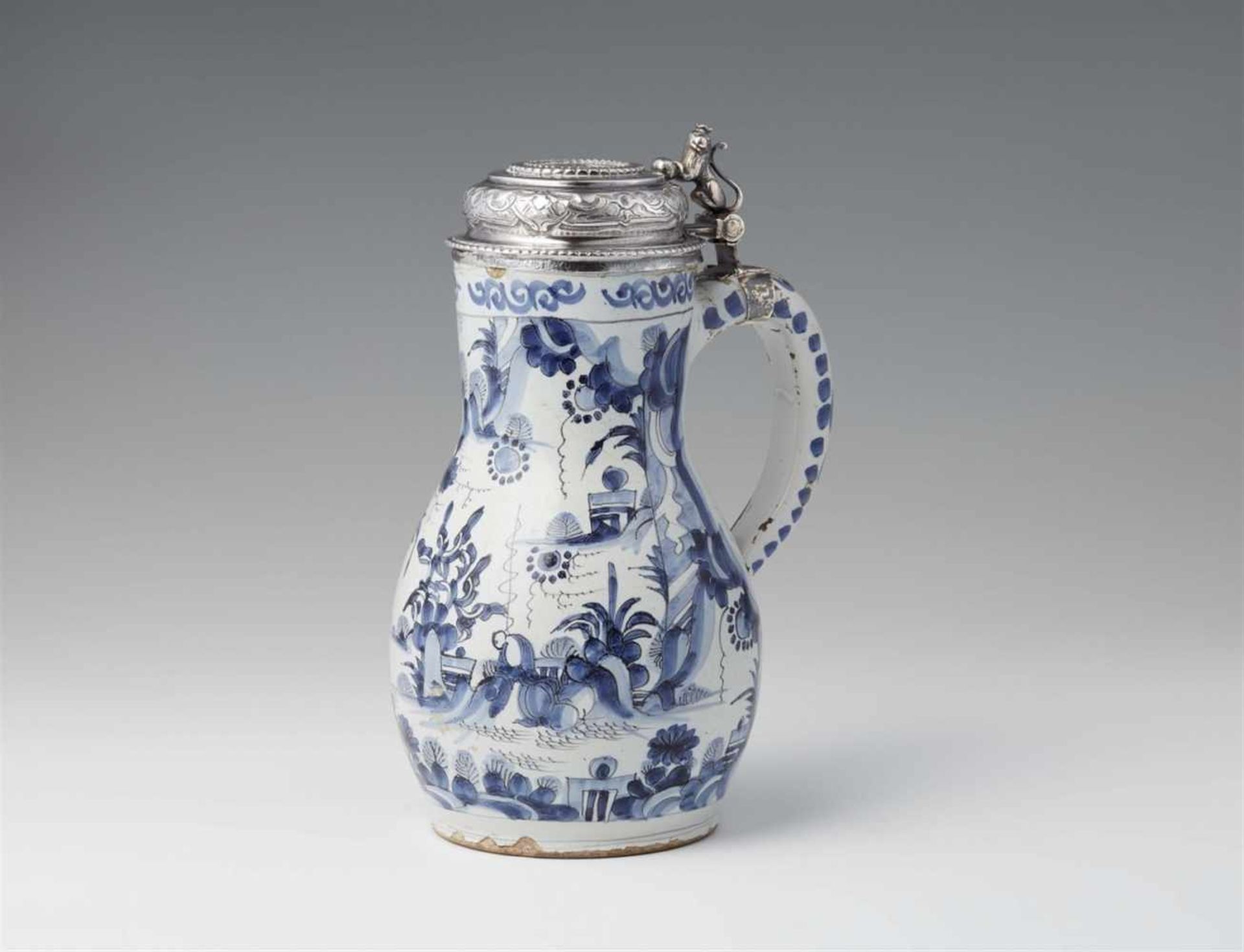 A Delftware pitcher with Danish silver mountingsPear-form faience jug with blue and white