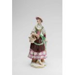 A Vienna porcelain figure of a lady as a maid with a basketA finely painted figure on a white