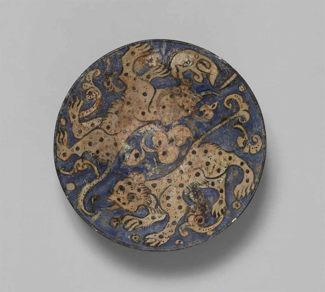 An Iranian fritware bowl with lion decorQuarz frit bowl with black decor on blue ground under