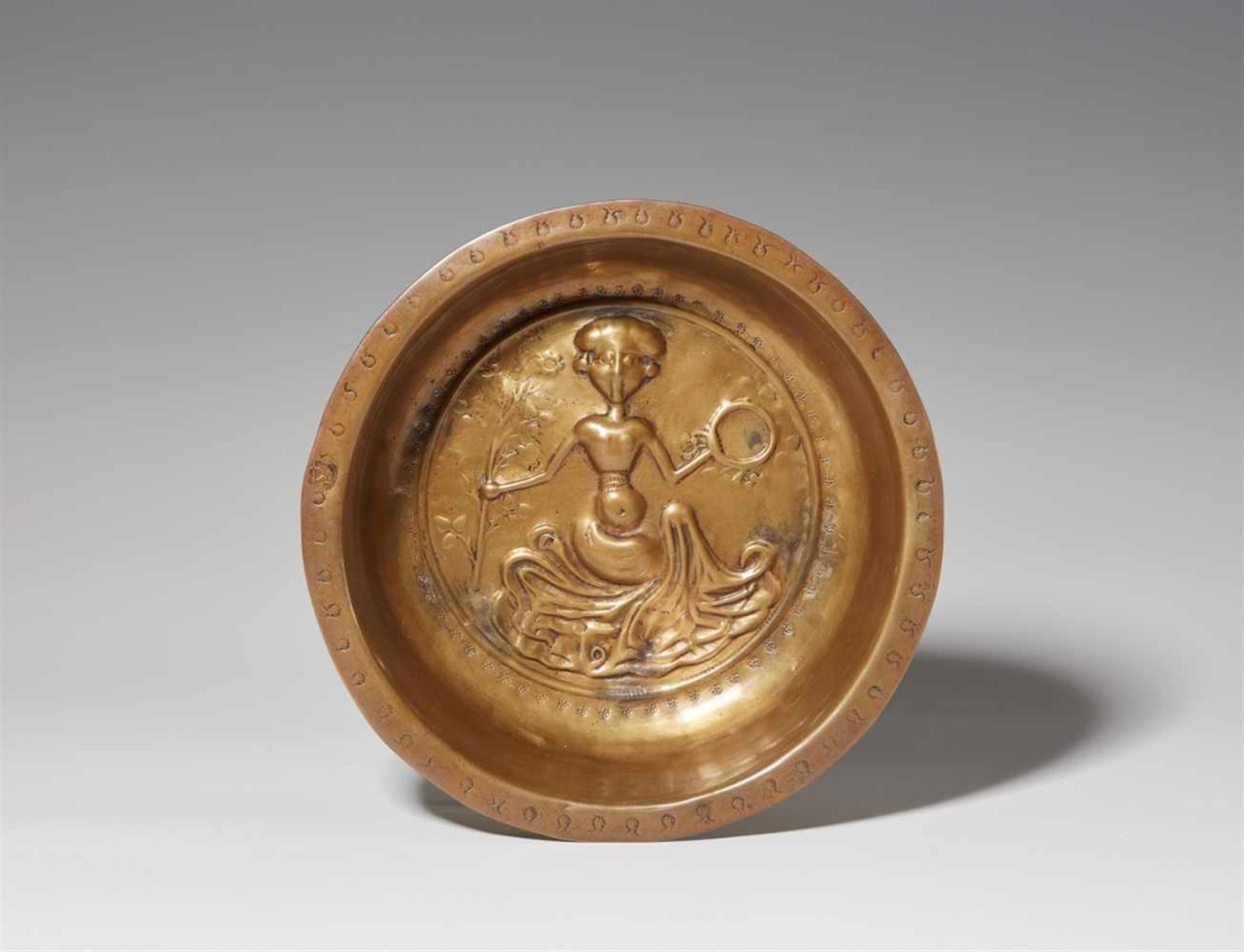 A South German brass basin with an allegory of VanitasDecorated to the centre with a lady sitting on