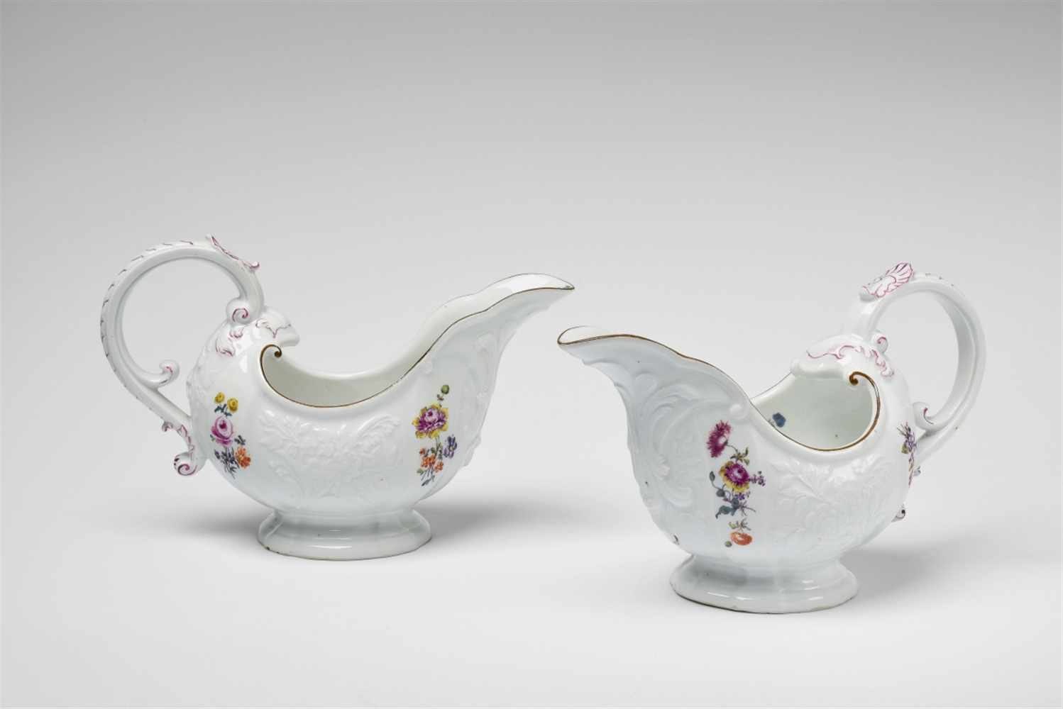A pair of Meissen porcelain sauce boats from a service with wildflower decorBlue crossed swords