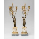 A pair of fire-gilt bronze candelabra with bacchantes.Fire-gilt bronze and marble three-flame