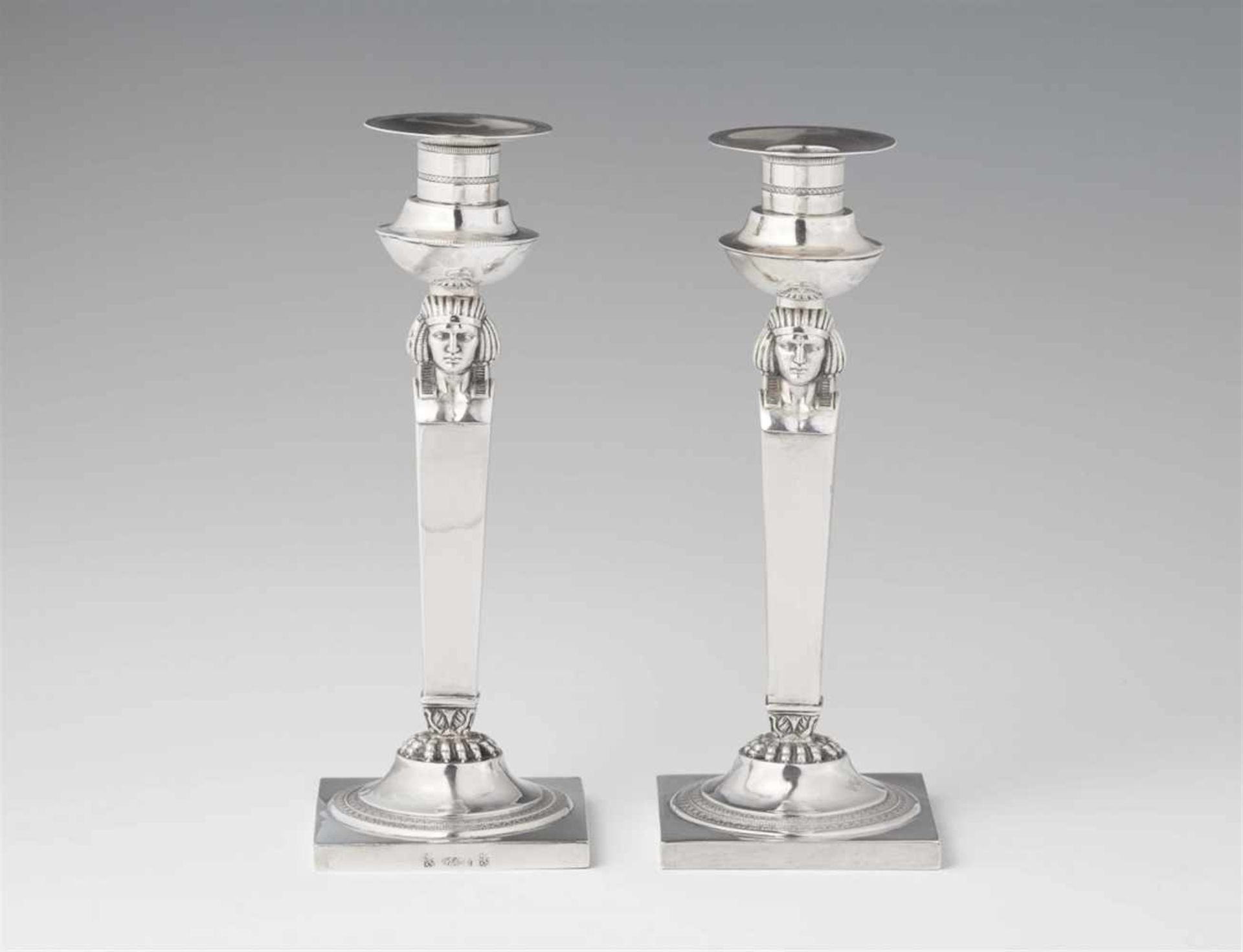 A pair of Frankfurt Empire silver candlesticksSquare plinths supporting tapering shafts with