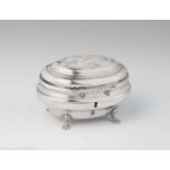 A Naumburg silver sugar boxBombé form box on four shell supports, the hinged lid with grapevine