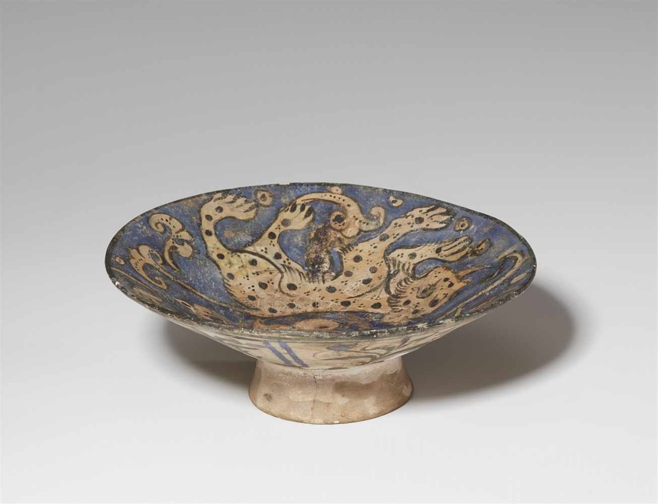 An Iranian fritware bowl with lion decorQuarz frit bowl with black decor on blue ground under - Image 2 of 3