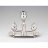 A Louis XVI silver writing setComprising a candlestick and two boxes on an oval tray resting on