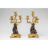 A pair of gilt bronze candelabra with children as an allegory of winterThree-flame candelabra cast