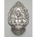 A silver holy water stoopRounded bowl with a cherub's head and tapering decorative back panel with