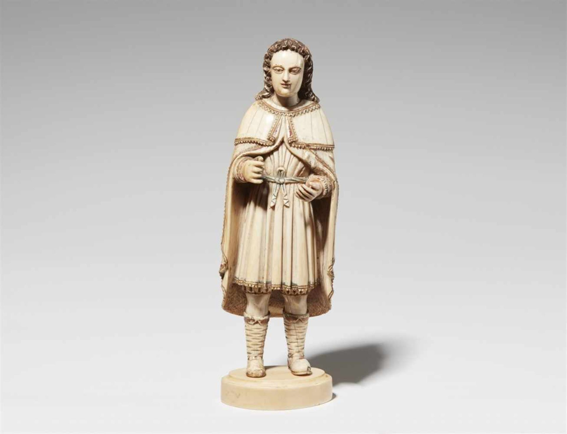 A carved ivory figure of a manWith remnants of polychromy and gilding. Figure of a man with curly