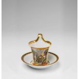 A Fürstenberg porcelain cup with a scene of porcelain makingCup with original saucer depicting a