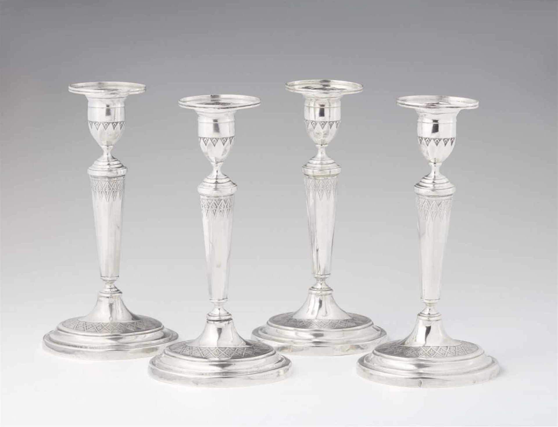 A set of four Augsburg silver candlesticksOval bases supporting fluted shafts and vase shaped