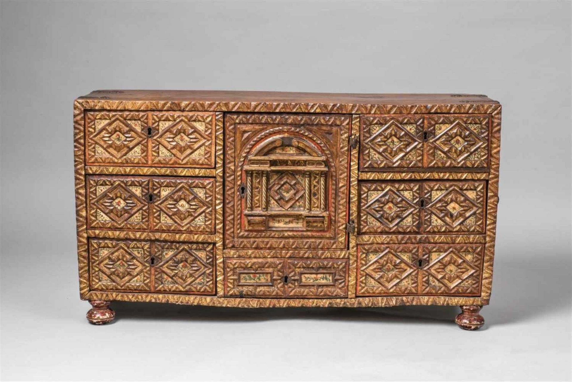 A Spanish carved walnut sideboardPartially gilt taquillón with painted alabaster top, cast iron