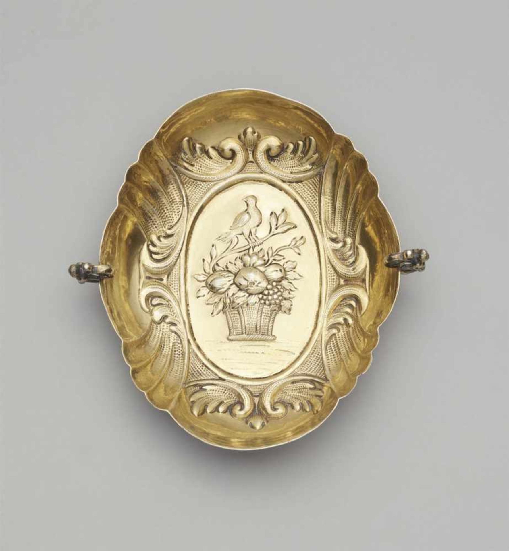 An Augsburg silver gilt brandy bowlOval scalloped dish with scroll handles and winged herms.