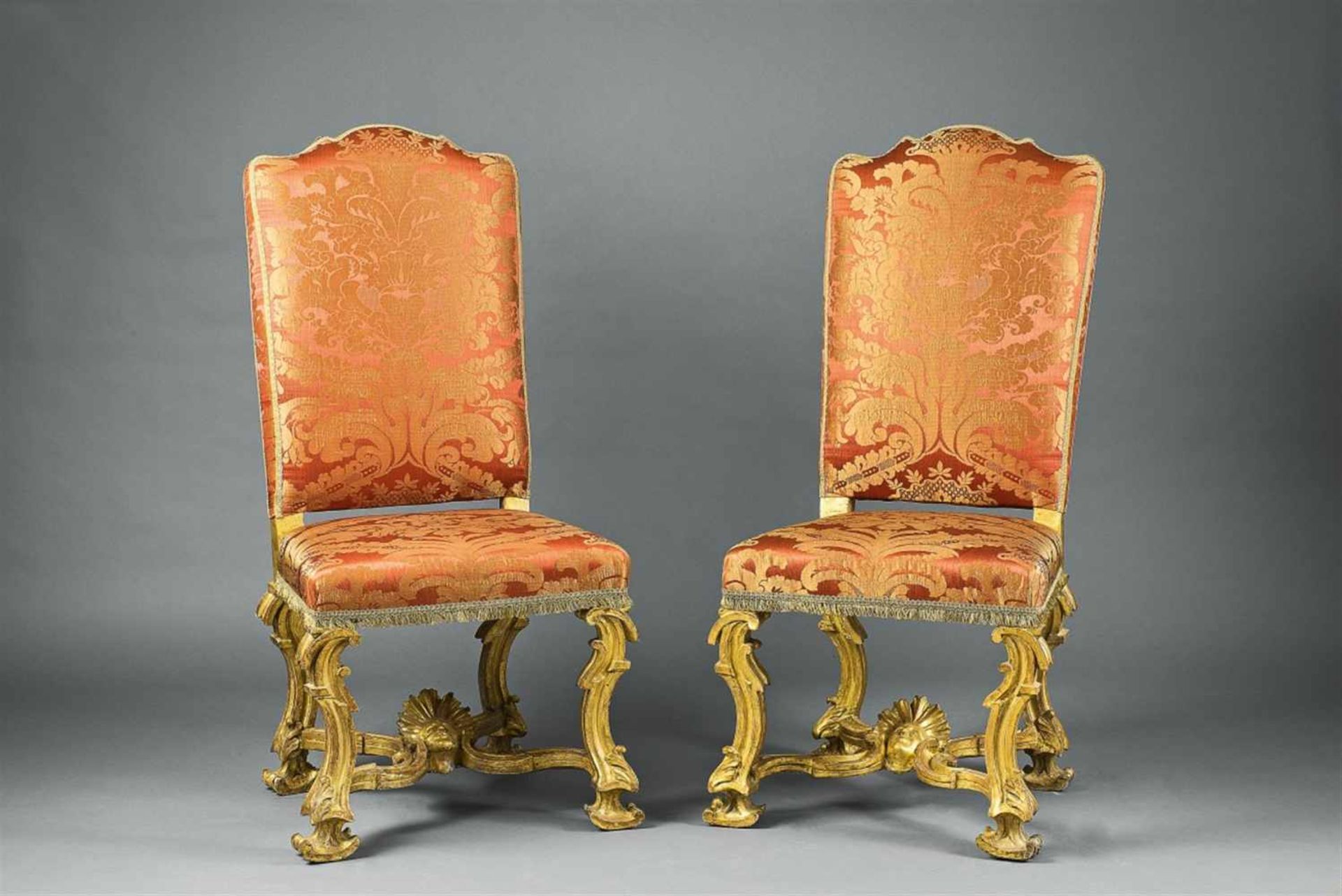 A pair of Roman carved walnut chairsWith later red damask upholstery. The gilding partially