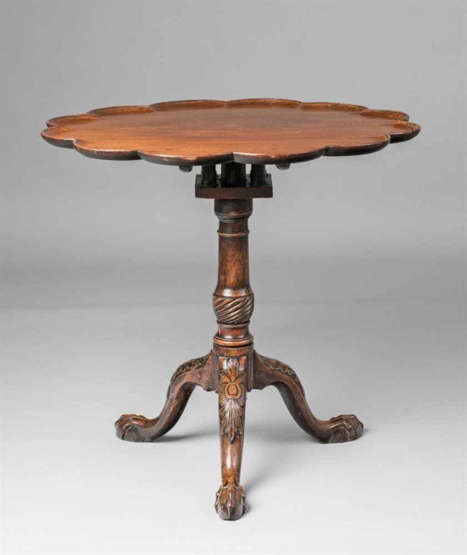 A George I style mahogany tripod tableLobed table top supported on turned and carved supports