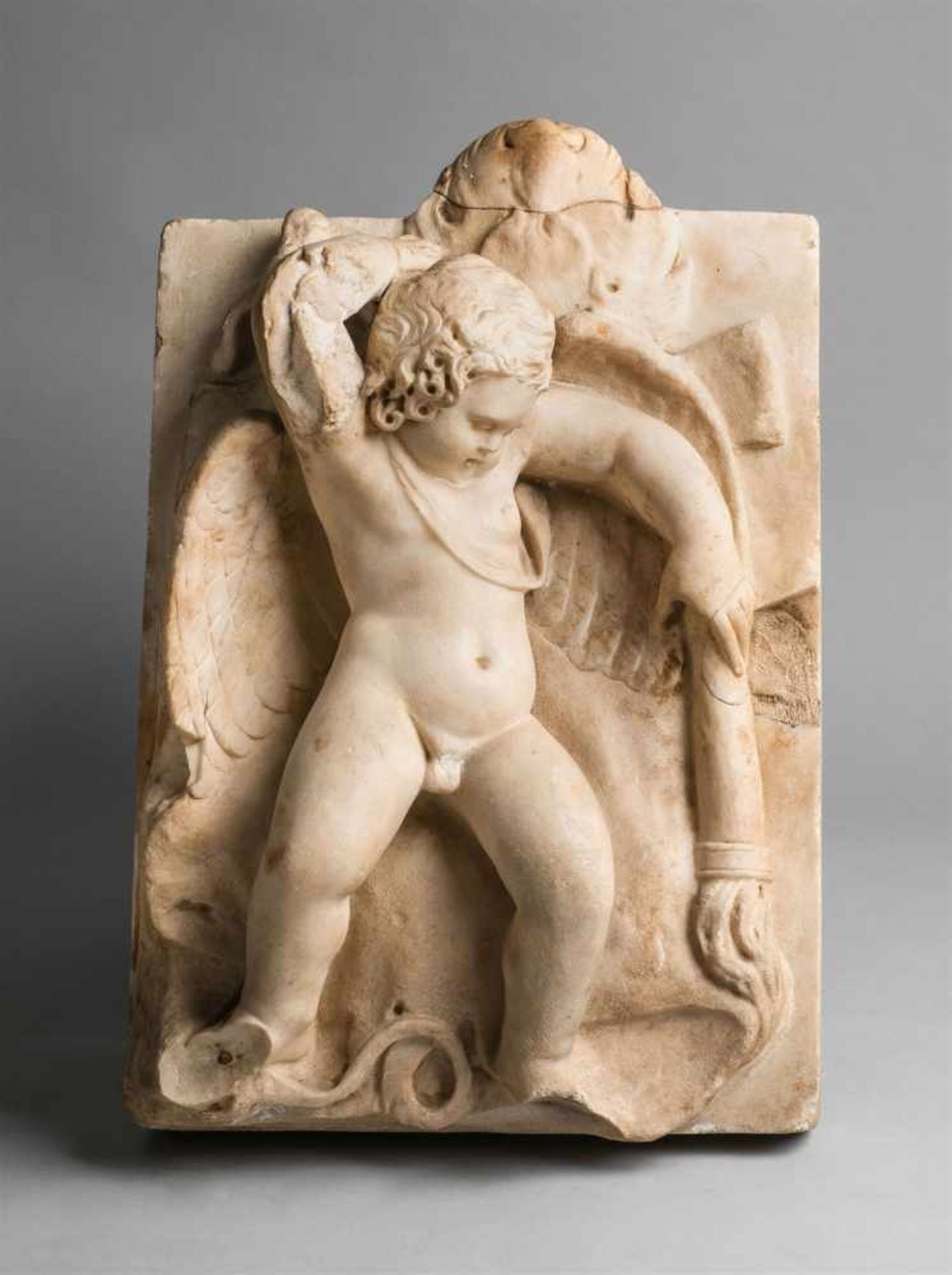 A Roman white marble relief of a Sleeping ErosDepicting a putto sleeping on outstretched wings