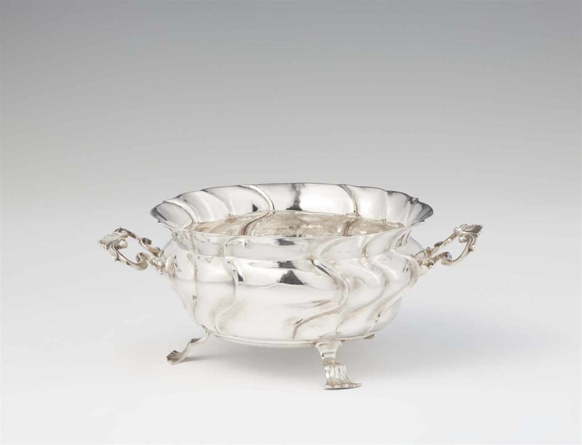 An Augsburg Rococo silver dishBombé form twist fluted dish with scroll handles resting on three