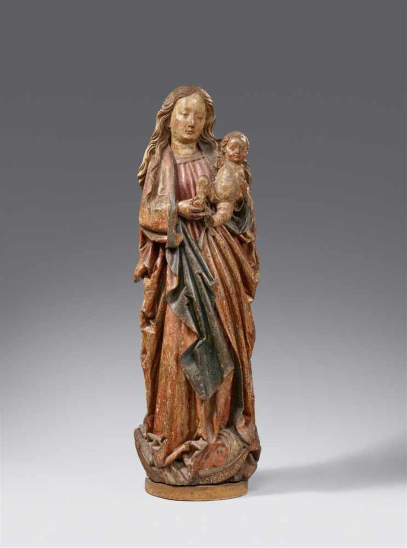A late 15th century Franconian carved wood figure of the Virgin and ChildCarved three-quarters in