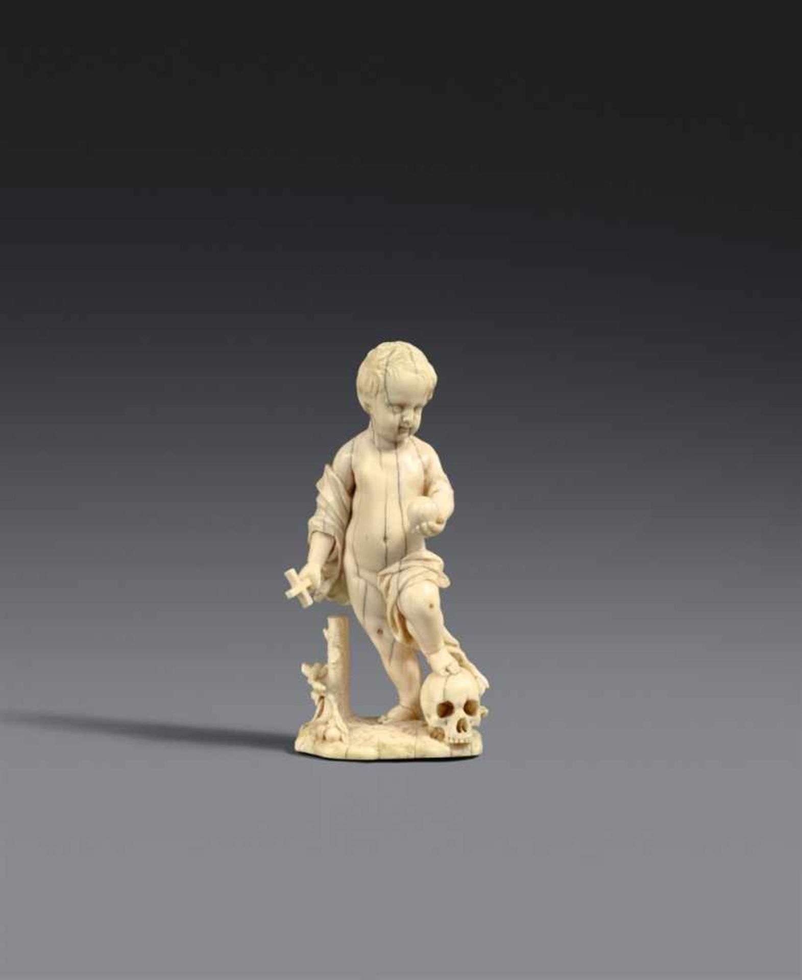 A 17th century carved ivory figure of Christ with a skull, probably South GermanCarved in the