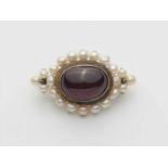 A 14k gold carbuncle cabochon broochOval brooch set with a garnet cabochon (ca. 14.10 x 10.39 x