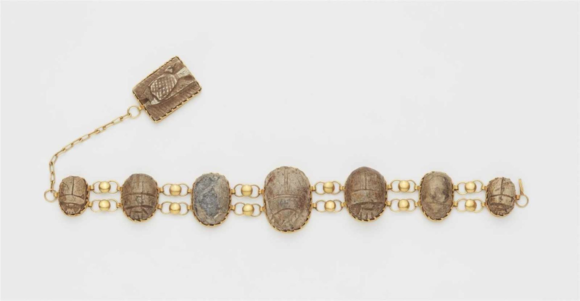 A 21k gold bracelet with scarab amuletsDesigned as a band of seven ancient Egyptian scarab beetle