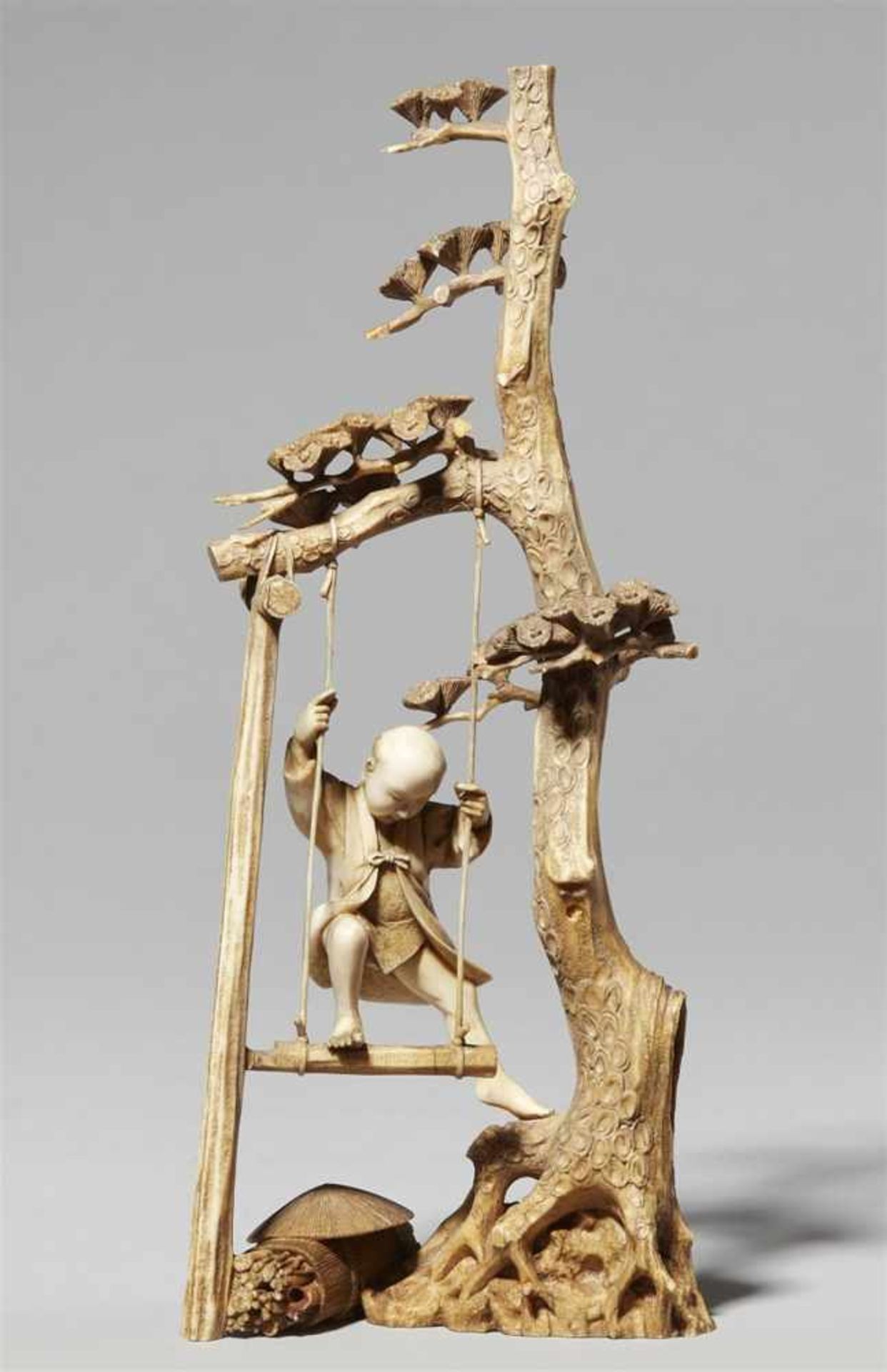 An ivory okimono of a boy on a swing. Late 19th century