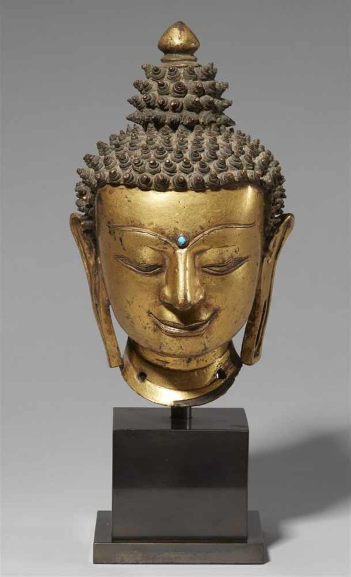 A precious Tibetan gilt bronze head of a Buddha. 14th/15th century